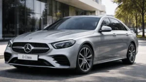 Silver Mercedes-Benz E-Class luxury sedan parked on a modern city street, front three-quarter view, premium executive car for chauffeur service